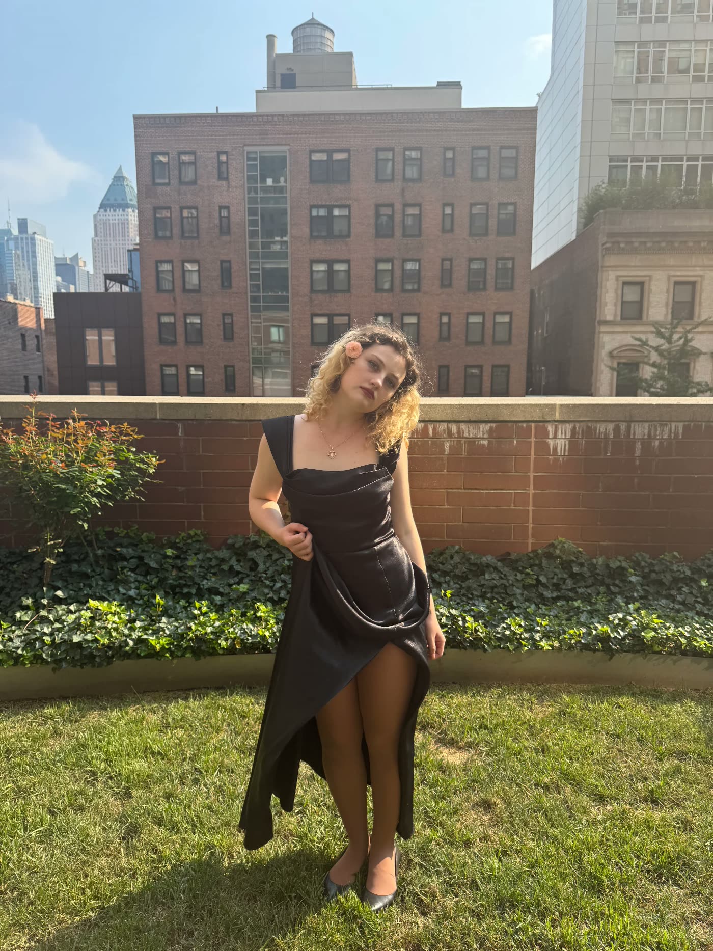 Isabel Irene standing on a rooftop in a black dress